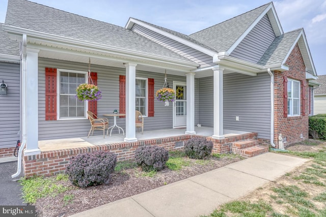 132 Nightingale Dr, Milford, DE 19963 - view of front of home featuring a porch, a shingled roof, crawl space, and brick siding