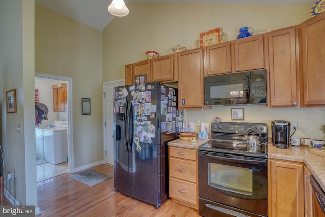 132 Nightingale Dr, Milford, DE 19963 - kitchen with black appliances, washing machine and clothes dryer, light countertops, light wood-style floors, and high vaulted ceiling