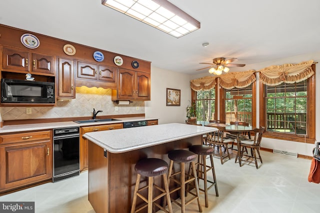12810 Kending Ln, Clear Spring, MD 21722 - kitchen featuring black appliances, light countertops, tasteful backsplash, a breakfast bar, and a kitchen island