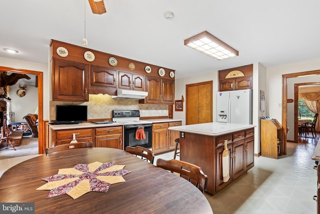 12810 Kending Ln, Clear Spring, MD 21722 - kitchen featuring electric range oven, under cabinet range hood, white refrigerator with ice dispenser, light countertops, and tasteful backsplash