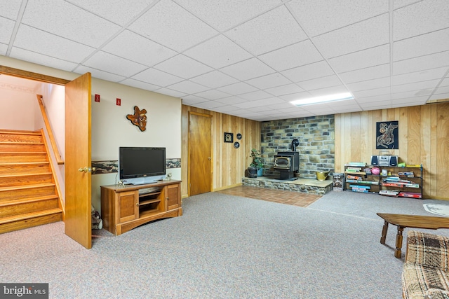 12810 Kending Ln, Clear Spring, MD 21722 - living room with a wood stove, stairs, carpet floors, wooden walls, and a paneled ceiling