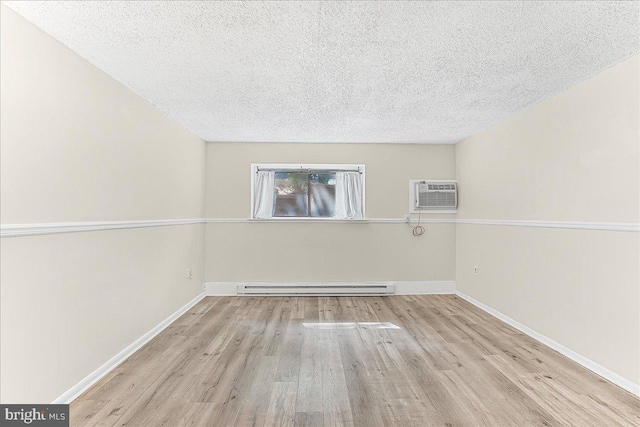 400 Glendale Rd Unit G-13, Havertown, PA 19083 - empty room featuring baseboard heating, wood finished floors, a wall mounted air conditioner, and a textured ceiling
