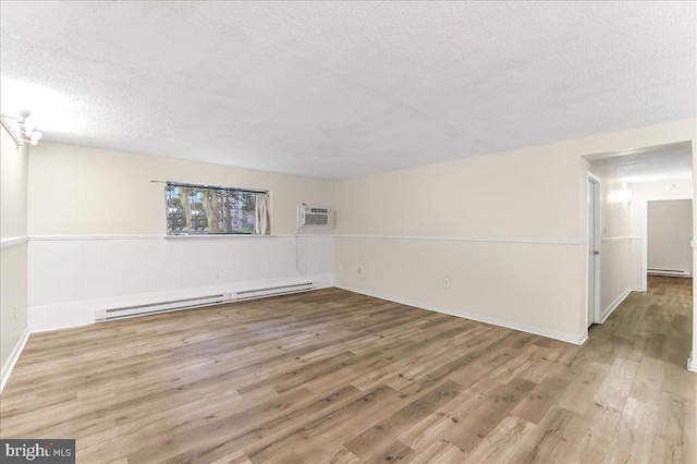 400 Glendale Rd Unit G-13, Havertown, PA 19083 - unfurnished room featuring a baseboard heating unit, a textured ceiling, wood finished floors, an AC wall unit, and a baseboard radiator
