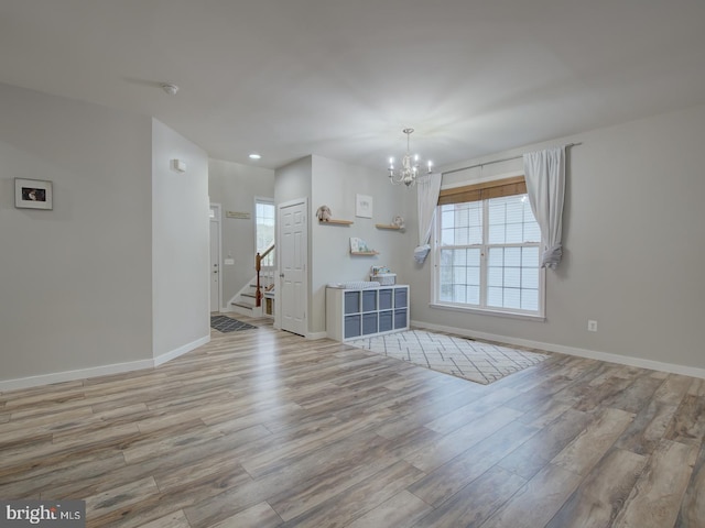 7436 Pensacola Pl, Gainesville, VA 20155 - unfurnished living room with a chandelier, wood finished floors, healthy amount of natural light, stairs, and recessed lighting
