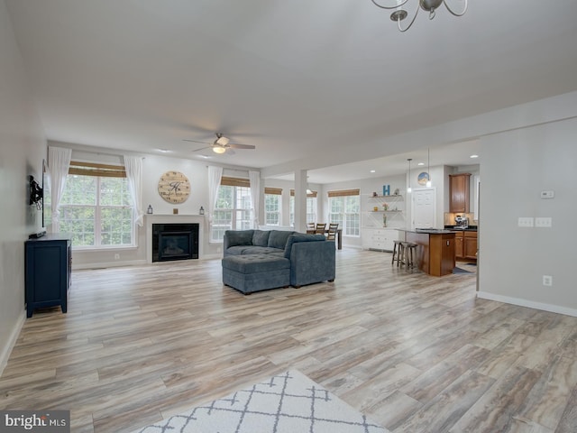 7436 Pensacola Pl, Gainesville, VA 20155 - living area with light wood-style floors, a ceiling fan, a glass covered fireplace, and recessed lighting