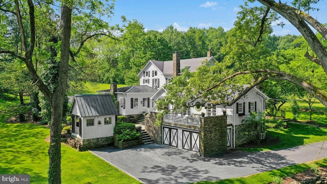 282 Crabapple Ln, East Stroudsburg, PA 18302 - view of front of home with asphalt driveway, stairs, a chimney, a front lawn, and an attached garage