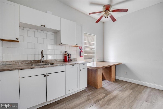 301 Broad St, Beverly, NJ 08010 - kitchen featuring a ceiling fan, white cabinets, backsplash, light wood-type flooring, and light stone countertops