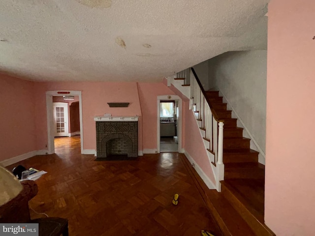 5122 Stenton Ave, Philadelphia, PA 19144 - unfurnished living room featuring a textured ceiling, stairs, and a fireplace