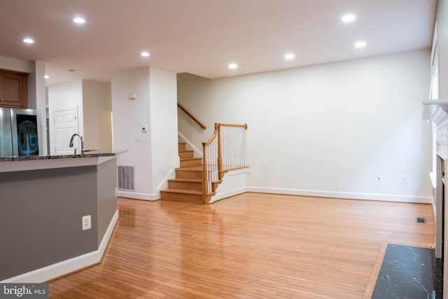 114 Herndon Mill Cir, Herndon, VA 20170 - kitchen with refrigerator, light wood finished floors, dark stone counters, recessed lighting, and a fireplace