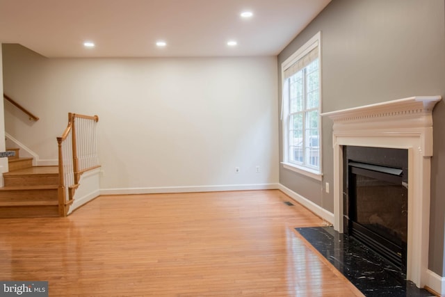 114 Herndon Mill Cir, Herndon, VA 20170 - unfurnished living room with wood finished floors, a fireplace with flush hearth, stairs, and recessed lighting