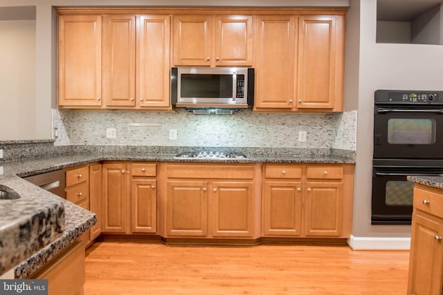 114 Herndon Mill Cir, Herndon, VA 20170 - kitchen featuring stainless steel appliances, light wood-style flooring, dark stone counters, and decorative backsplash