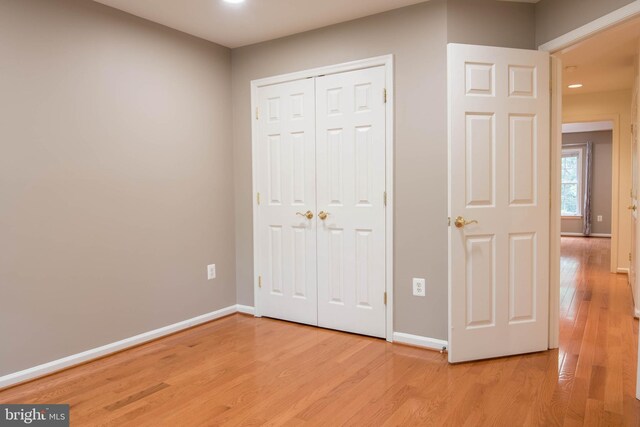 114 Herndon Mill Cir, Herndon, VA 20170 - unfurnished bedroom featuring light wood-style flooring, a closet, and recessed lighting
