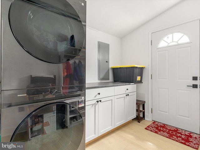 13222 Parson Ln, Fairfax, VA 22033 - laundry room featuring stacked washer / dryer, electric panel, light wood-type flooring, and cabinet space