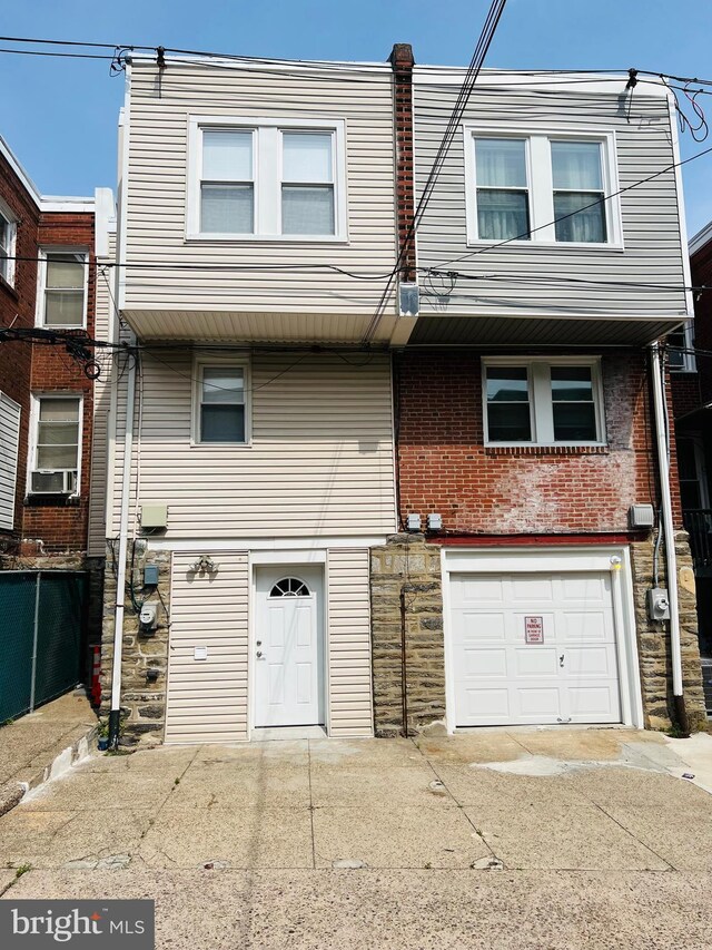 6610 N Smedley St, Philadelphia, PA 19126 - view of front facade with an attached garage, concrete driveway, stone siding, and brick siding