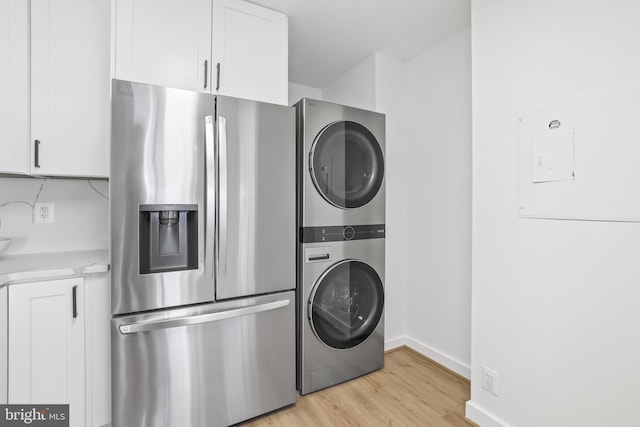 205 Yoakum Pkwy Unit 1712, Alexandria, VA 22304 - washroom featuring stacked washer and clothes dryer and light wood finished floors
