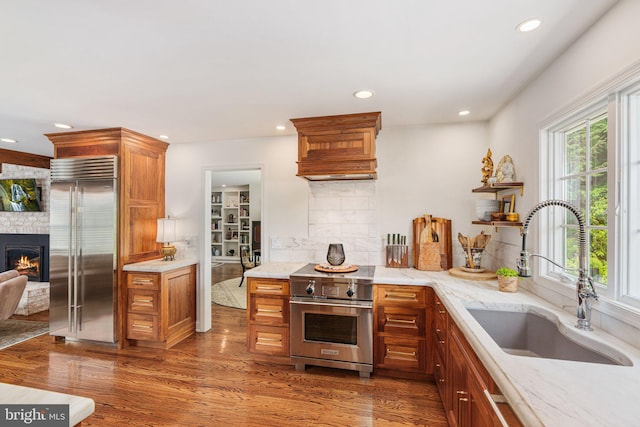 4704 Sweetbriar Cir, Emmaus, PA 18049 - kitchen featuring high quality appliances, recessed lighting, a fireplace, backsplash, and wood finished floors