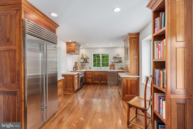 4704 Sweetbriar Cir, Emmaus, PA 18049 - kitchen with high end appliances, brown cabinets, open shelves, light countertops, and wood finished floors
