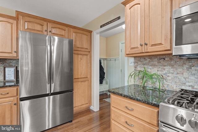 1817 Old Farm Ln, Lancaster, PA 17602 - kitchen featuring appliances with stainless steel finishes, wood finished floors, decorative backsplash, and dark stone countertops