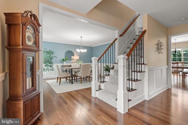 1817 Old Farm Ln, Lancaster, PA 17602 - staircase featuring a chandelier, wood-type flooring, a decorative wall, a wainscoted wall, and crown molding