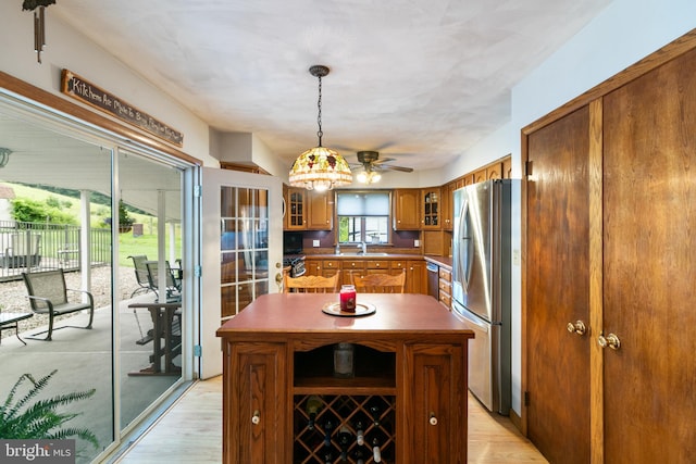 848 Rapp Rd, Howard, PA 16841 - kitchen featuring stainless steel appliances, brown cabinets, light wood-type flooring, and glass insert cabinets