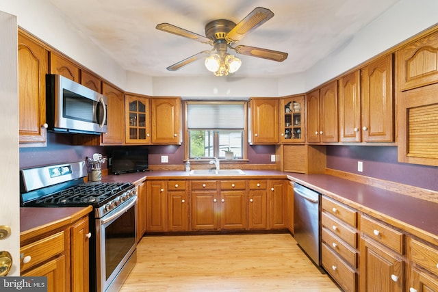 848 Rapp Rd, Howard, PA 16841 - kitchen with appliances with stainless steel finishes, brown cabinetry, light wood finished floors, and glass insert cabinets