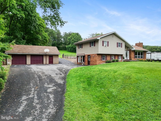 848 Rapp Rd, Howard, PA 16841 - split level home with a front yard, a detached garage, a chimney, an outbuilding, and brick siding