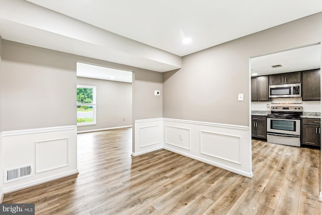 12 Bantry Ct, Waldorf, MD 20602 - kitchen with appliances with stainless steel finishes, dark brown cabinetry, light wood-style floors, wainscoting, and light countertops