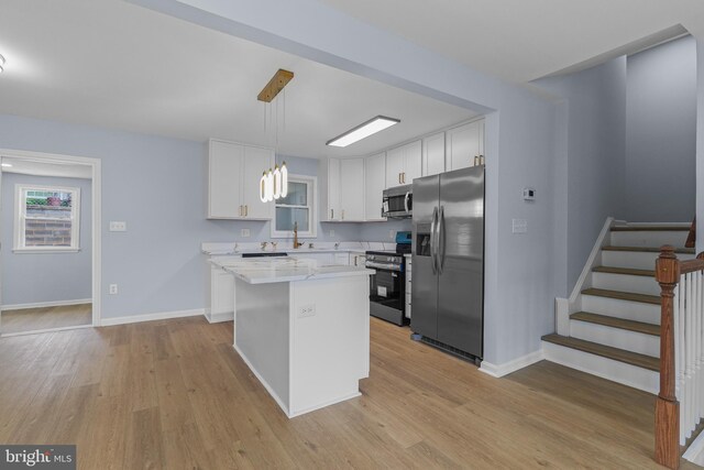 7306 Gavin St, Hyattsville, MD 20784 - kitchen featuring appliances with stainless steel finishes, light wood finished floors, white cabinetry, and a center island