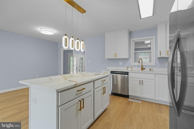 7306 Gavin St, Hyattsville, MD 20784 - kitchen with stainless steel appliances, light wood finished floors, a center island, and white cabinetry