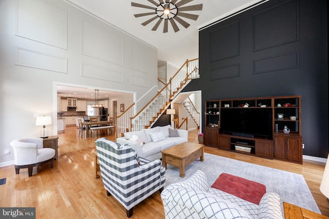 1568 Tattersall, West Chester, PA 19380 - living area featuring stairway, light wood-style floors, a high ceiling, and a chandelier