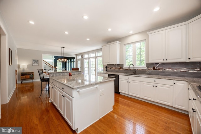 1568 Tattersall, West Chester, PA 19380 - kitchen with dishwashing machine, a center island, tasteful backsplash, a chandelier, and light wood-type flooring