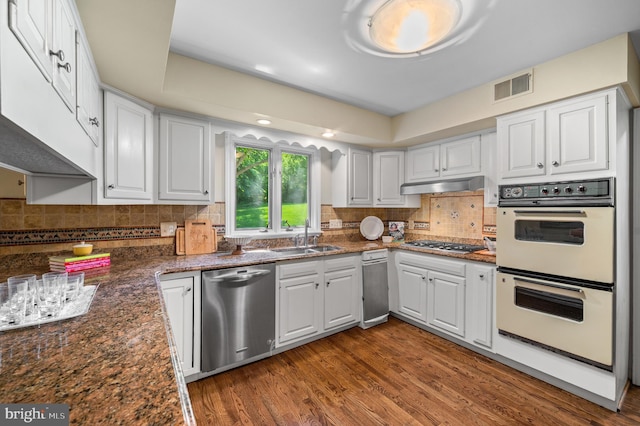 130 Hunt Valley Cir, Berwyn, PA 19312 - kitchen with stainless steel appliances, white cabinetry, wood finished floors, under cabinet range hood, and tasteful backsplash