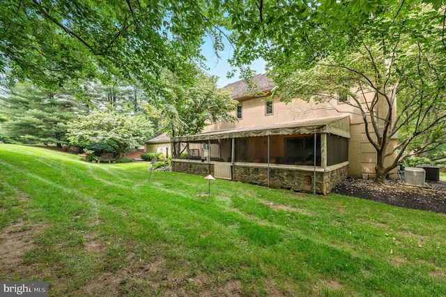 130 Hunt Valley Cir, Berwyn, PA 19312 - back of house featuring stone siding, a sunroom, and a yard