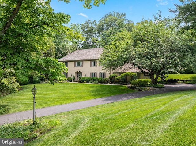 130 Hunt Valley Cir, Berwyn, PA 19312 - colonial house featuring a front lawn, stucco siding, and driveway