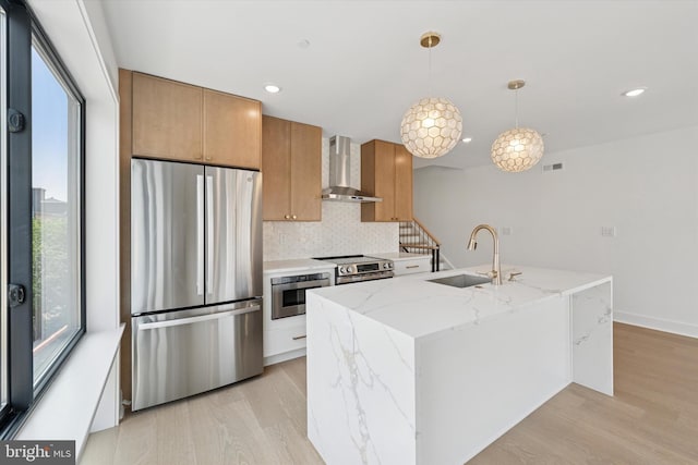 919 S 11th St Unit A, Philadelphia, PA 19147 - kitchen with appliances with stainless steel finishes, wall chimney range hood, light wood-style flooring, decorative backsplash, and recessed lighting