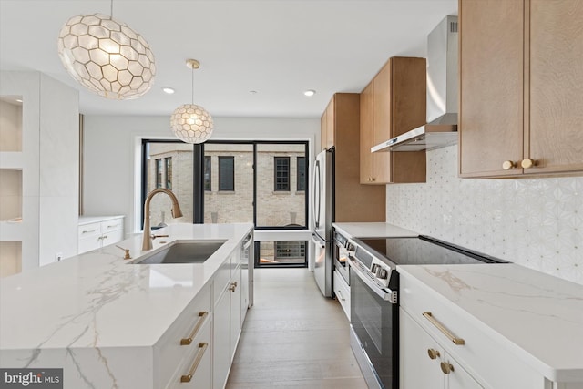 919 S 11th St Unit A, Philadelphia, PA 19147 - kitchen with wall chimney exhaust hood, stainless steel appliances, a center island with sink, light wood-style floors, and light stone countertops