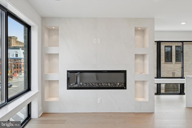 919 S 11th St Unit A, Philadelphia, PA 19147 - unfurnished living room featuring built in shelves, wood finished floors, a glass covered fireplace, and recessed lighting