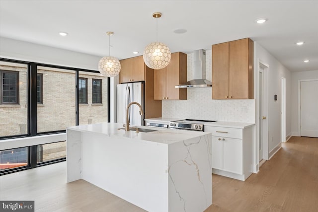 919 S 11th St Unit A, Philadelphia, PA 19147 - kitchen featuring wall chimney exhaust hood, appliances with stainless steel finishes, light wood-style flooring, light stone countertops, and recessed lighting