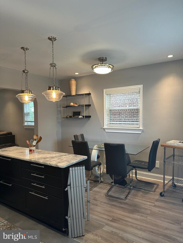 4627 12th St NE, Washington, DC 20017 - kitchen with light wood-style floors, dark cabinetry, recessed lighting, light stone counters, and decorative light fixtures