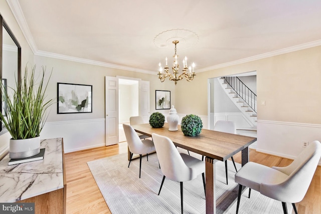 1517 Tuba Ct, Vienna, VA 22182 - dining room featuring stairs, a chandelier, ornamental molding, light wood finished floors, and a wainscoted wall