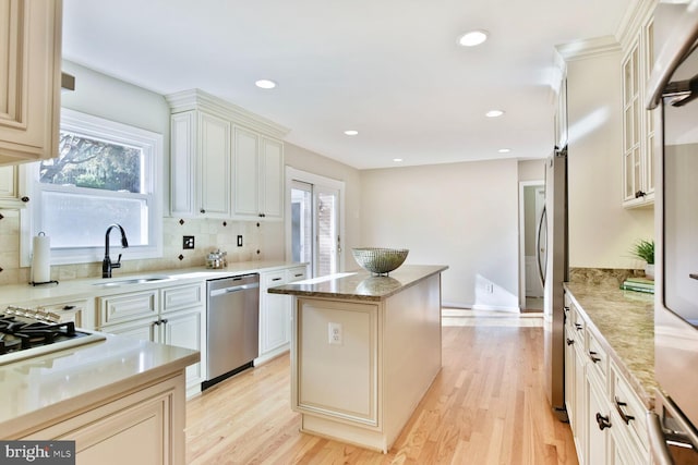 1517 Tuba Ct, Vienna, VA 22182 - kitchen with stainless steel dishwasher, a kitchen island, decorative backsplash, light wood-type flooring, and recessed lighting