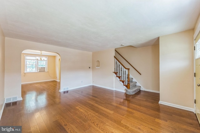 2864 Cushing Rd, Camden, NJ 08104 - empty room with arched walkways, a chandelier, wood finished floors, and stairway