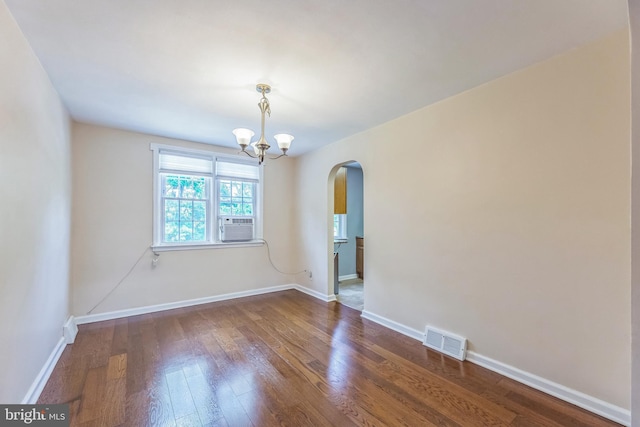 2864 Cushing Rd, Camden, NJ 08104 - empty room featuring arched walkways, wood finished floors, and a chandelier