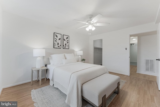 3460 Summit Ct NE Unit 3460, Washington, DC 20018 - bedroom featuring a spacious closet, light wood-style flooring, a ceiling fan, and a closet