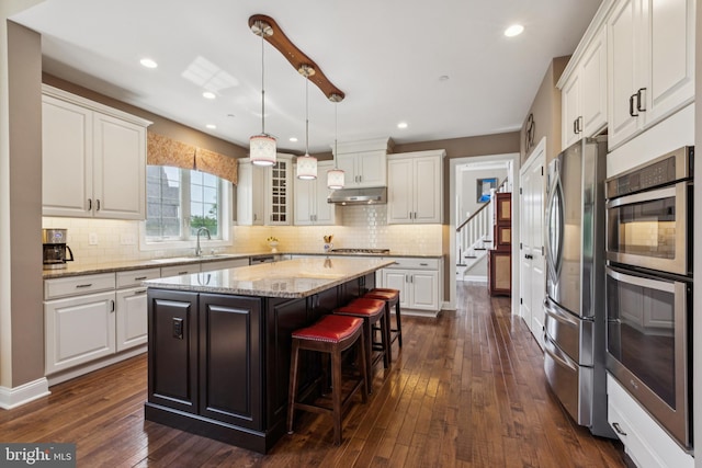 3132 Butternut Ln, Chester Springs, PA 19425 - kitchen featuring appliances with stainless steel finishes, under cabinet range hood, a kitchen island, white cabinetry, and recessed lighting