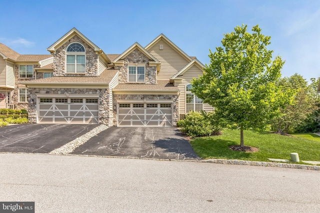 3132 Butternut Ln, Chester Springs, PA 19425 - view of front facade with stone siding, driveway, a garage, and a front lawn