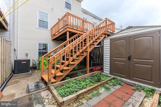 2129 Fort Donelson Ct, Dumfries, VA 22026 - back of property featuring a storage shed, stairs, a garden, and a deck