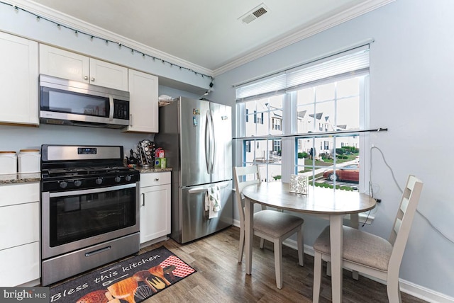 2129 Fort Donelson Ct, Dumfries, VA 22026 - kitchen featuring appliances with stainless steel finishes, crown molding, white cabinetry, light wood-type flooring, and stone countertops