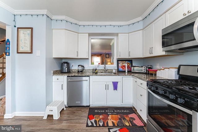 2129 Fort Donelson Ct, Dumfries, VA 22026 - kitchen with appliances with stainless steel finishes, dark wood-type flooring, white cabinets, dark stone countertops, and ornamental molding