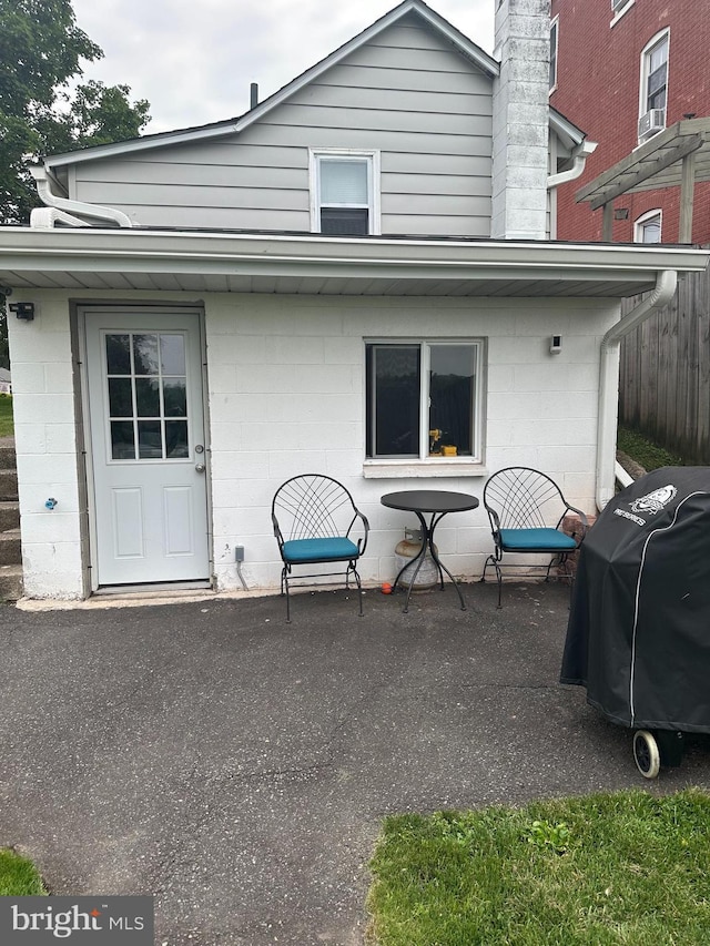 884 Main St, Pennsburg, PA 18073 - rear view of house with concrete block siding and a patio